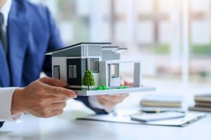 住宅模型を持つ男性のイメージ画像